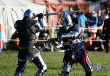 Abbey medieval festival image of two knights n amour fighting with swords.