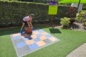 Young girl moving block on concrete maze at Amaze World.