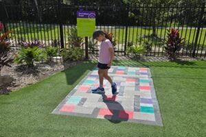 Young girl walking on concrete tri colour maze at Amaze World.