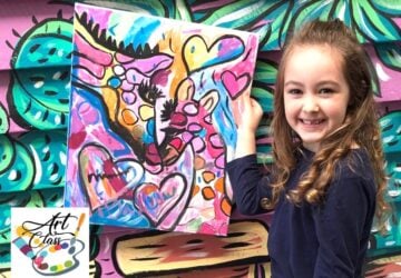 Smiling girl displaying her artwork