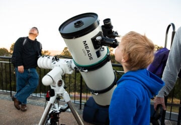 child looking through telescope at Mt Coot-tha