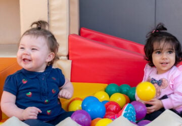 two toddlers playing with colourful balls