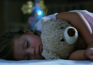 baby sleeping soundly with teddy bear