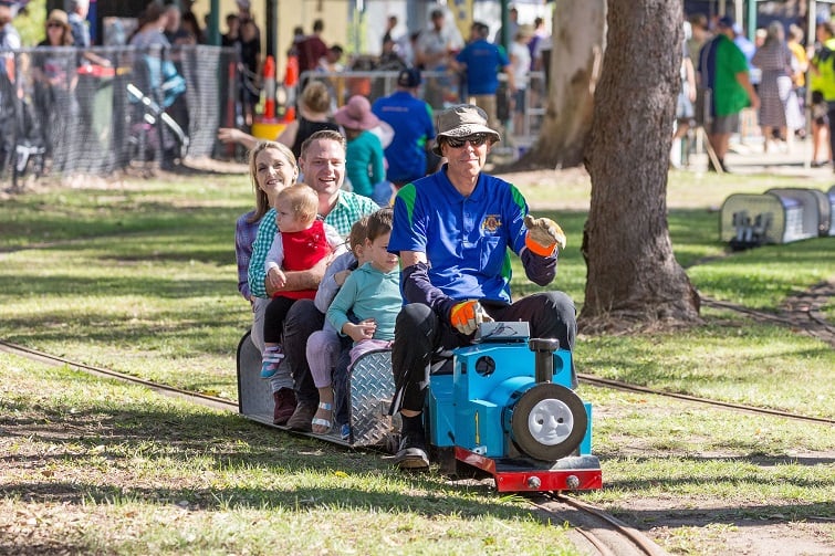 Bracken Ridge Lion's Train Day image of family riding on miniature Thomas the tank engine