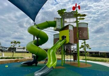 Large green playing tower with two slides at Castamore Way Park.