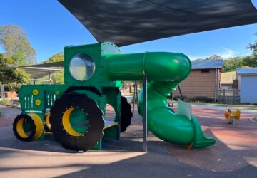 Green tractor fort and slide at Country Paradise Parklands in Nerang.