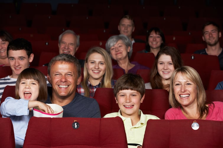 Families watching a movie at the movie theatre.
