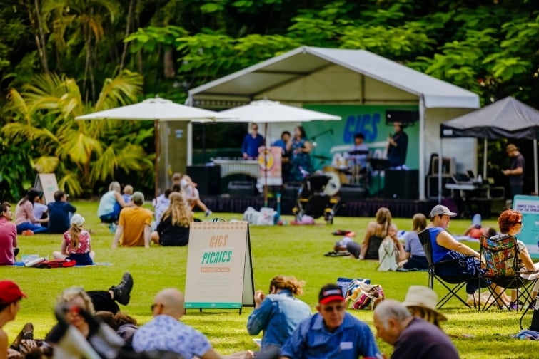 Gigs and picnics event image of people sitting in the botanic gardens listening to music.