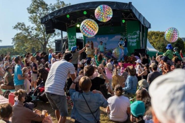 Green Heart Fair event image of Bluey and Bingo on stage with families in the crowd.