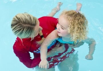 Girl in swimming pool with instructor