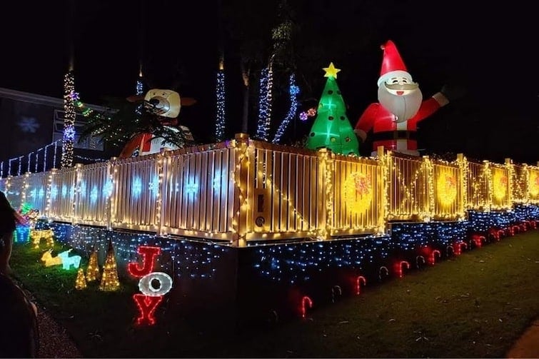 Lots of Christmas inflatables and lights on display at night.