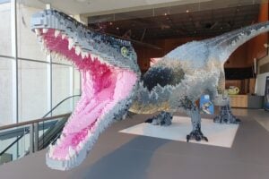 A large grey dinosaur in the foyer of the Queensland Museum at Jurassic World by Brickman.