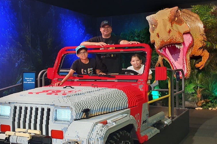 A family posing in the Jeep at Jurassic World by Brickman.