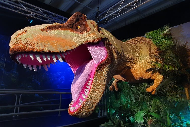 A large T-rex made of LEGO coming out of the wall at Jurassic World by Brickman.