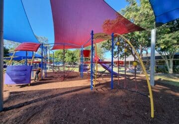 Colourful climbing play equipment covered by shade sails at Lanham Park.