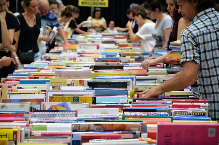 LIfeline Bookfest image of people looking through hundreds of books on a table.