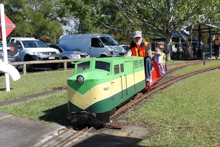 Logan Model Train rides event image of green miniature train.