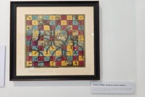 An early snakes and ladders game on display at The Mathema Gallery.