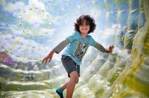 moreton kids festival event image of boy inside vortex ball.