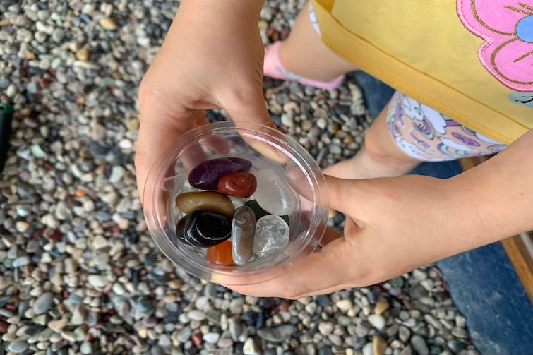 A child holding a tub of gems at Opals Down Under.