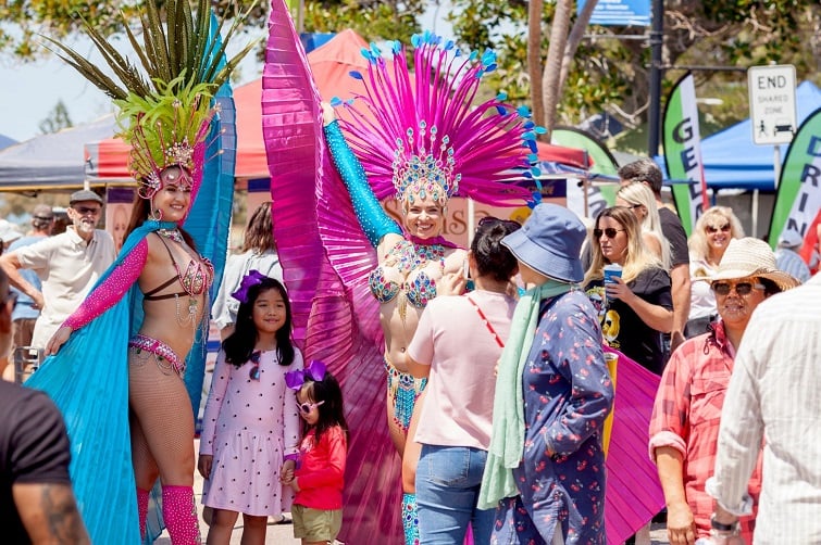 Redcliffe Market street party image of 2 samba dancers posing with families