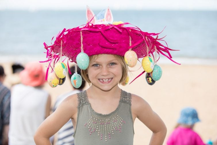 Redcliffe Festival of Sails image of a girl in an Easter bonnet on the beach.