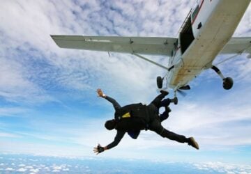 Tandem skydivers jumping out of a plane.