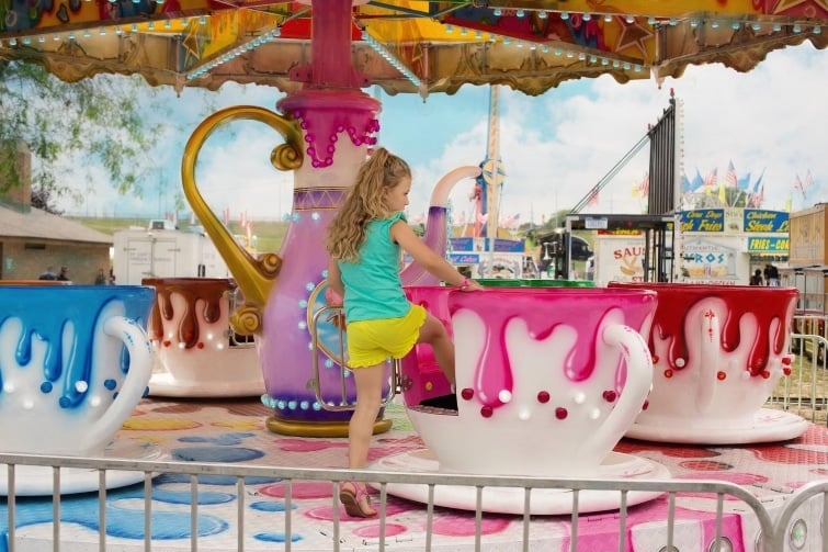 teacup ride at fair fete event image of girl getting onto teacup rides.