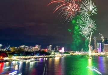 The lord mayor's new year's eve fireworks image of red and green fireworks over the city and Brisbane river.