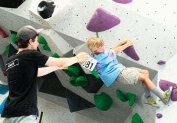 Urban Climb coach with young boy climbing wall.