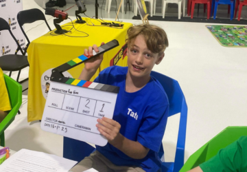 The Buzz Media Co student with clapperboard.